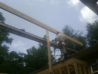 Carpenter setting a ridge beam over a new addition frame — Ice Dam Removal by Roofing Brothers in Mosier