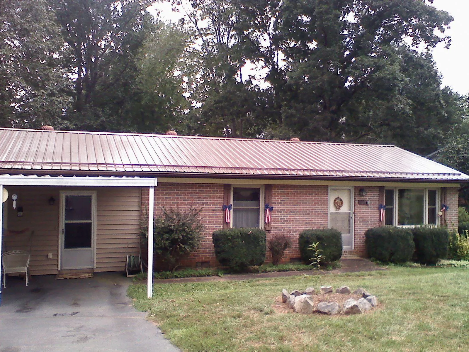 Bronze metal roof and carport on a brick ranch home — Roof Repair work by our crew in Mosier